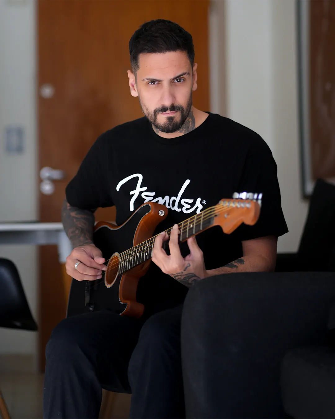 Guille, luthier y profesor de guitarra, tocando una guitarra electroacústica Fender negra